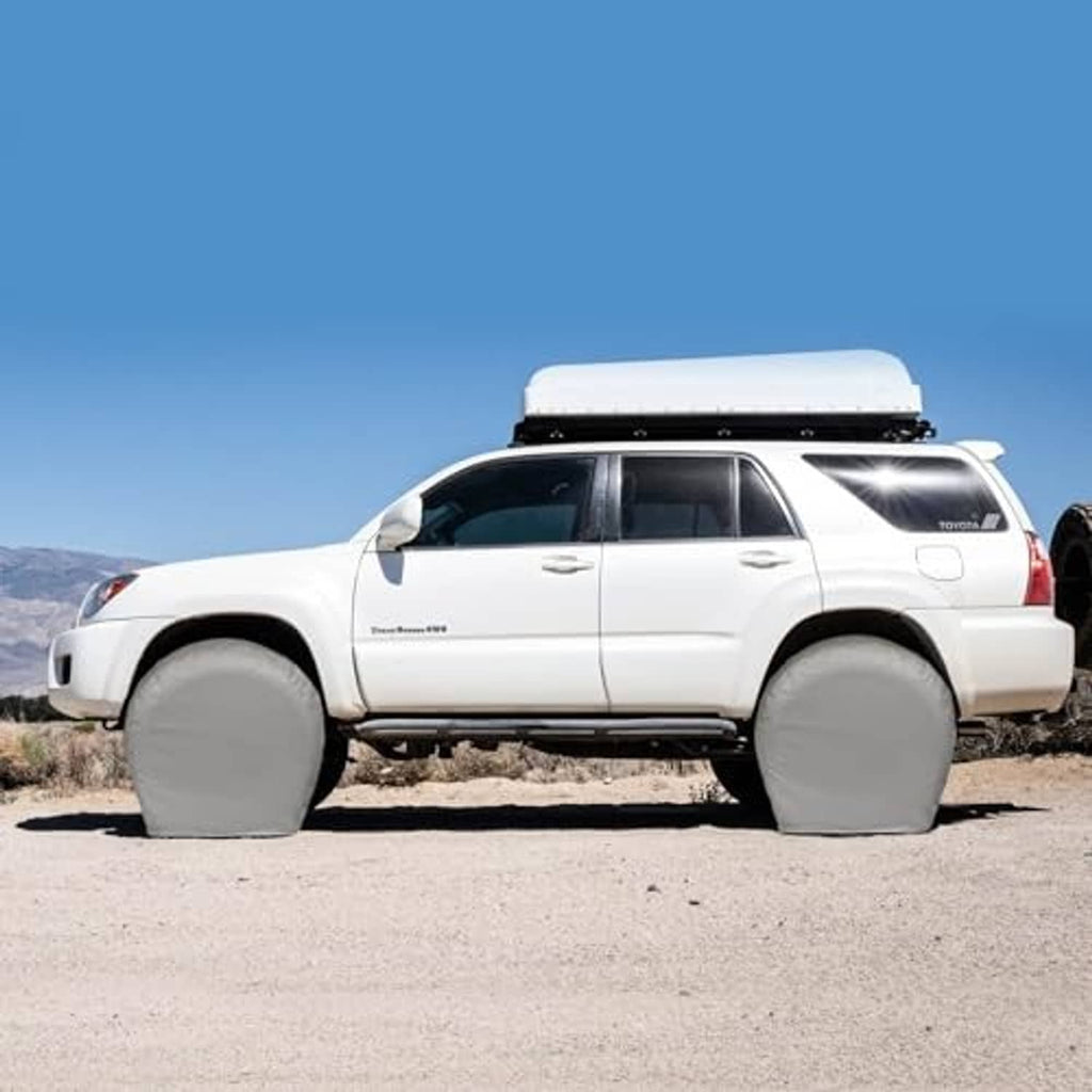 Gray tire covers on both sides of a parked SUV wheel set
