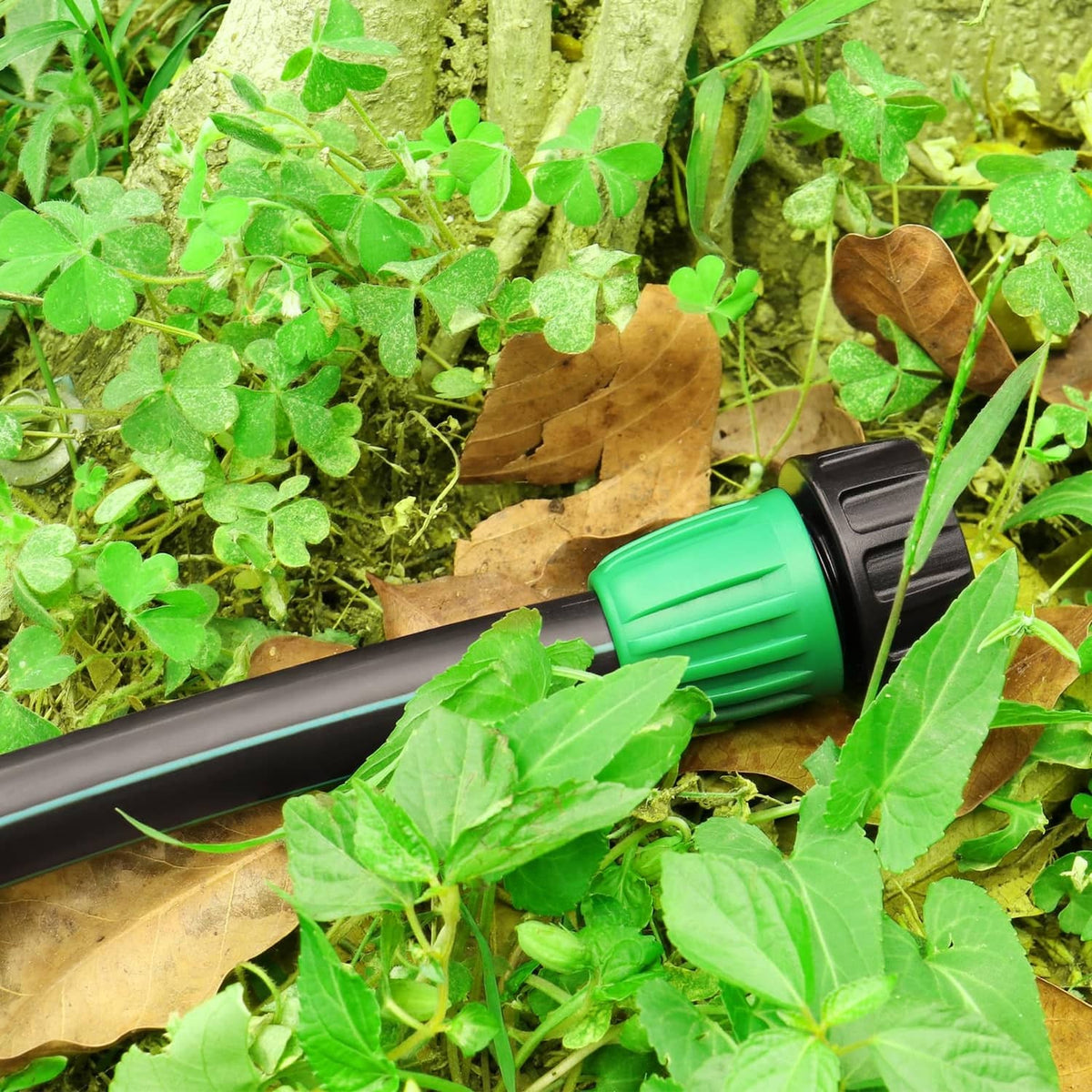 Green and black drip adapter fitting on black irrigation tubing