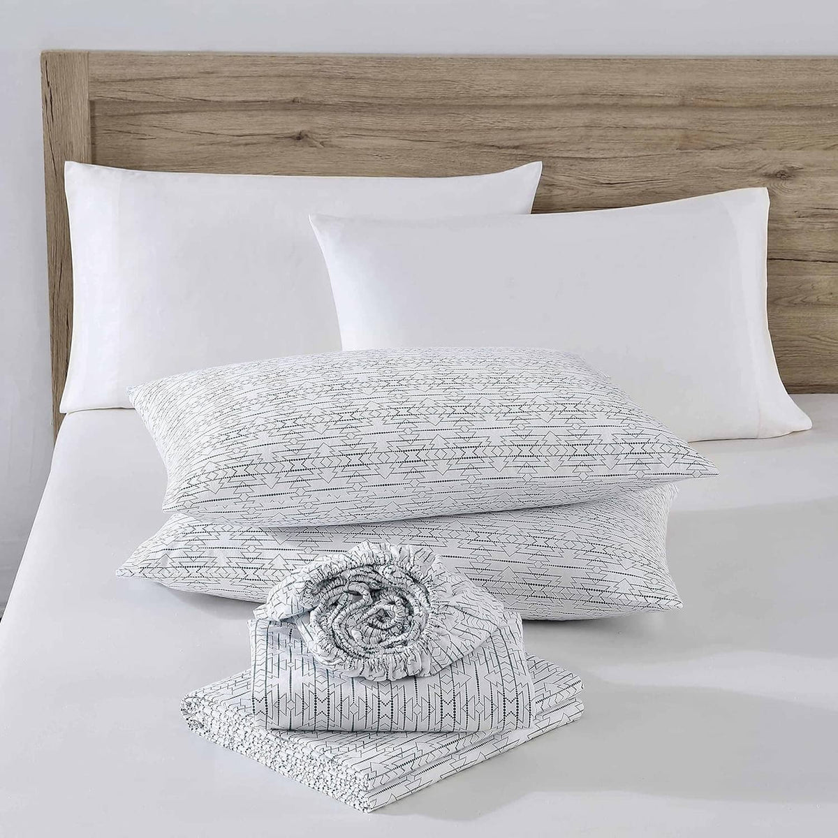 Queen sheet set featuring white pillowcases with navy geometric accents and matching comfort