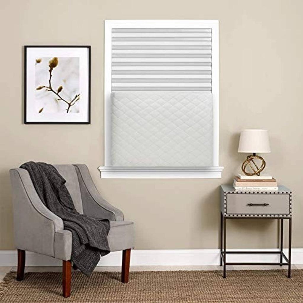 Beige quilted indoor AC cover on window-mounted air conditioner, rectangular front cover