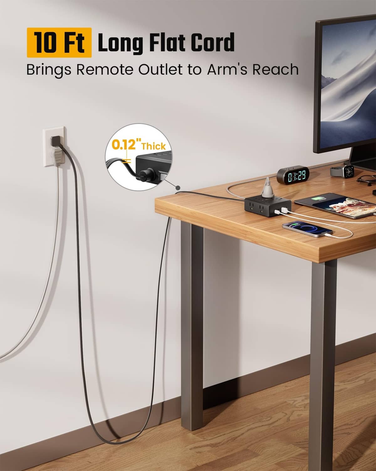 Black long flat extension cord reaching a wall outlet behind a desk