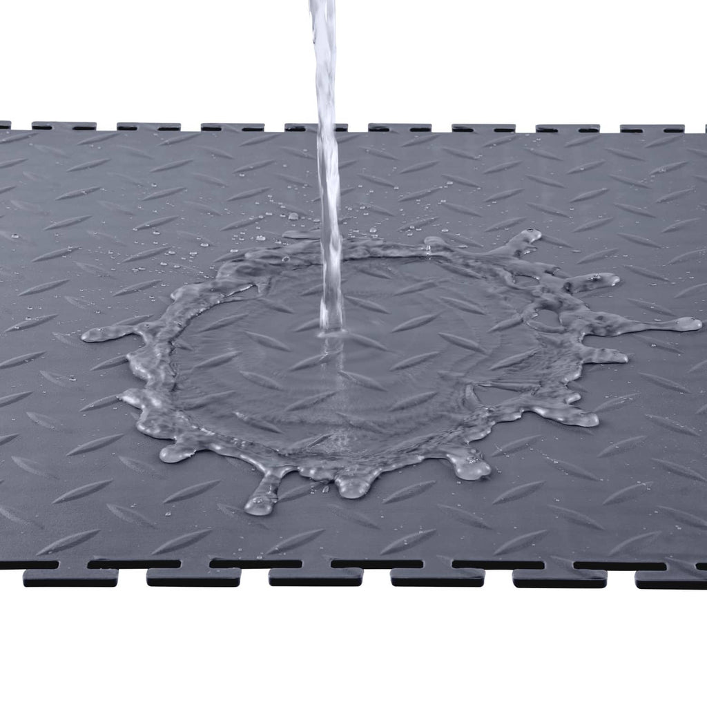 Gray PVC interlocking garage floor tile with raised diamond texture and water on surface