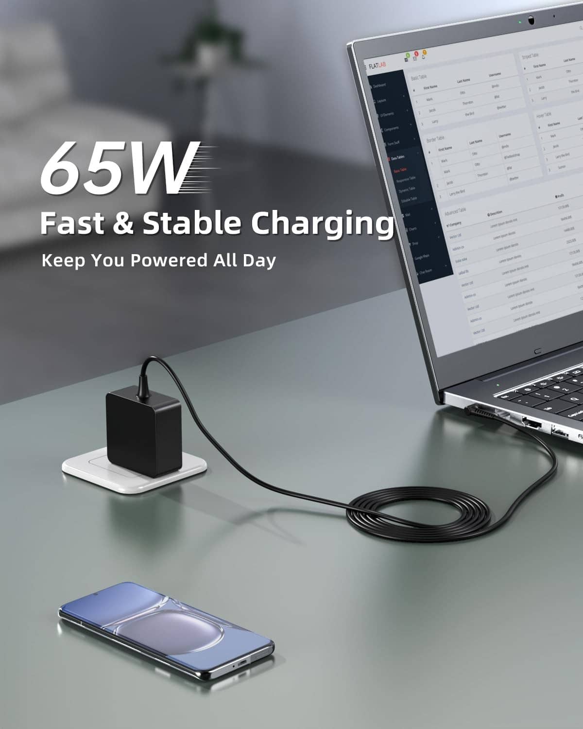 Black 65W laptop charger connected to a laptop and phone via cable