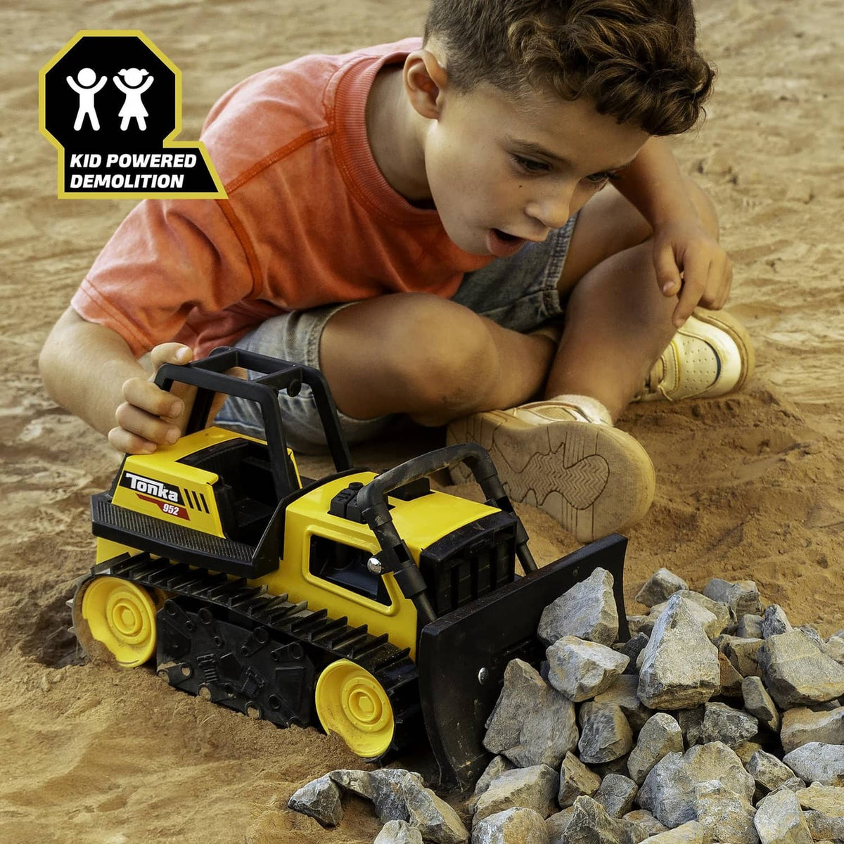 Child playing with yellow Tonka bulldozer toy with front blade