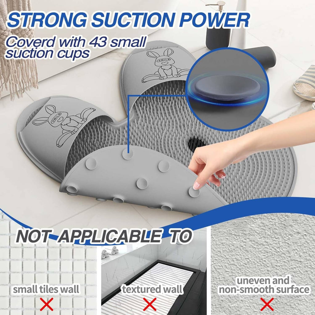 Gray shower foot scrubber mat with suction cups on underside, hand pressing center