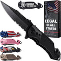 Black folding pocket knife with serrated blade and textured grip, shown with product box