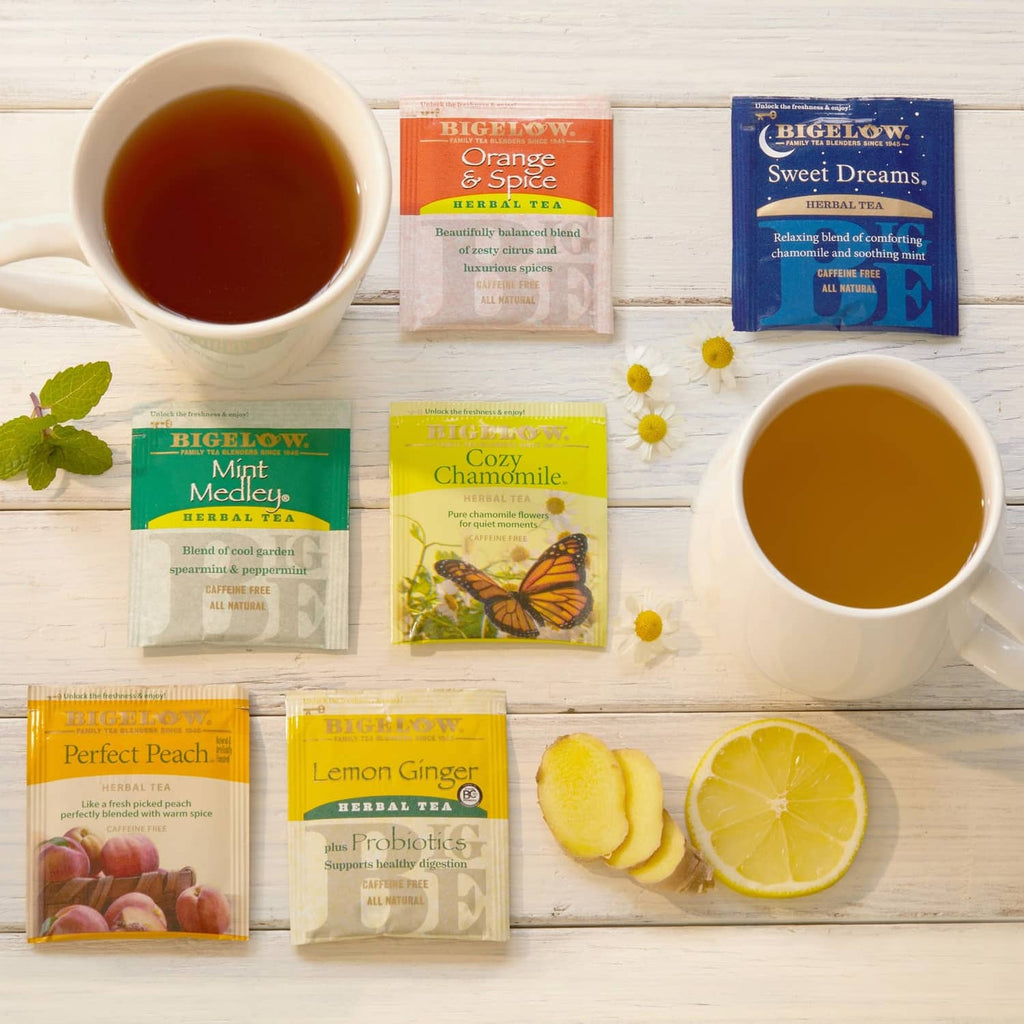 Herbal tea variety with brewed cups, tea packets, lemon and fruit garnish on a tray