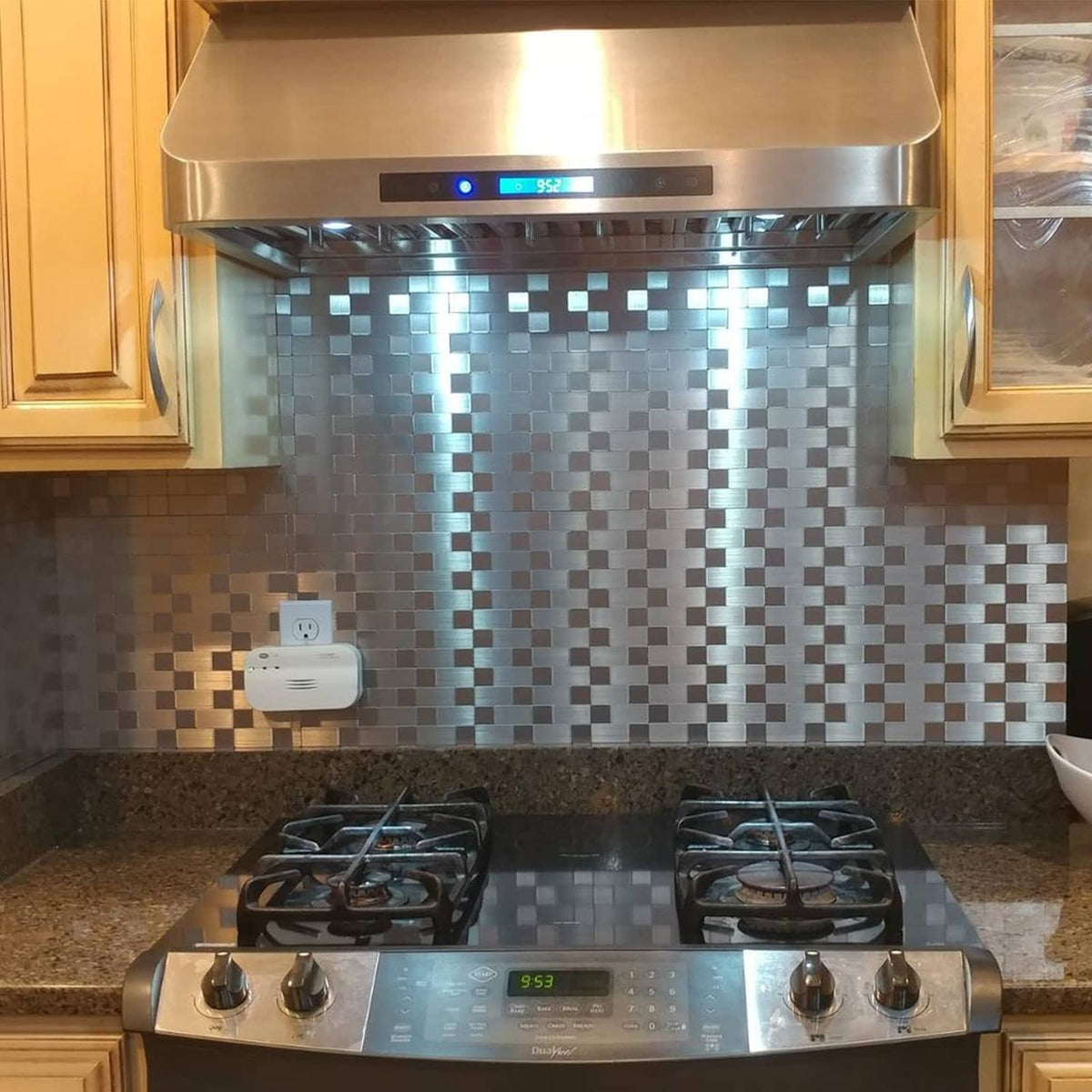 Stainless-look metal backsplash tiles with gray and white small square brick pattern
