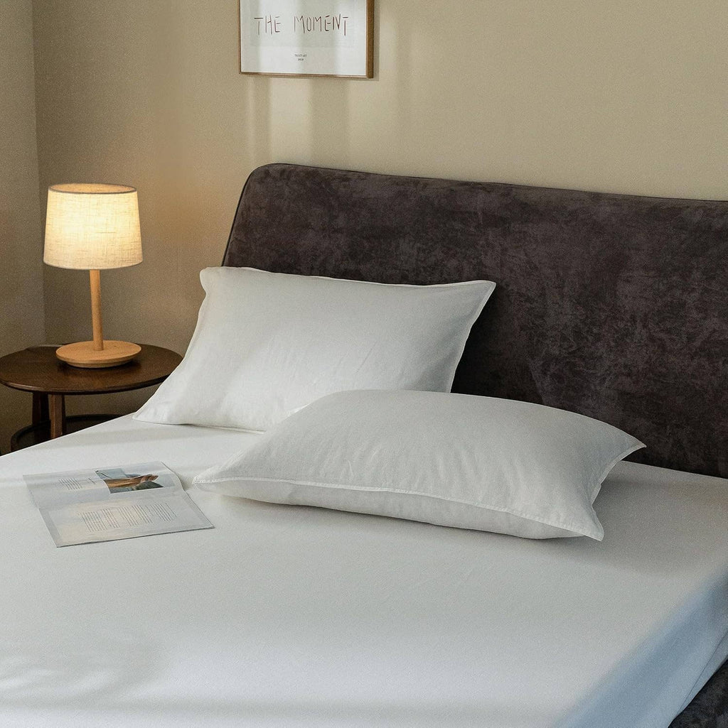 White linen pillowcases and fitted sheet with smooth fabric and gentle folds