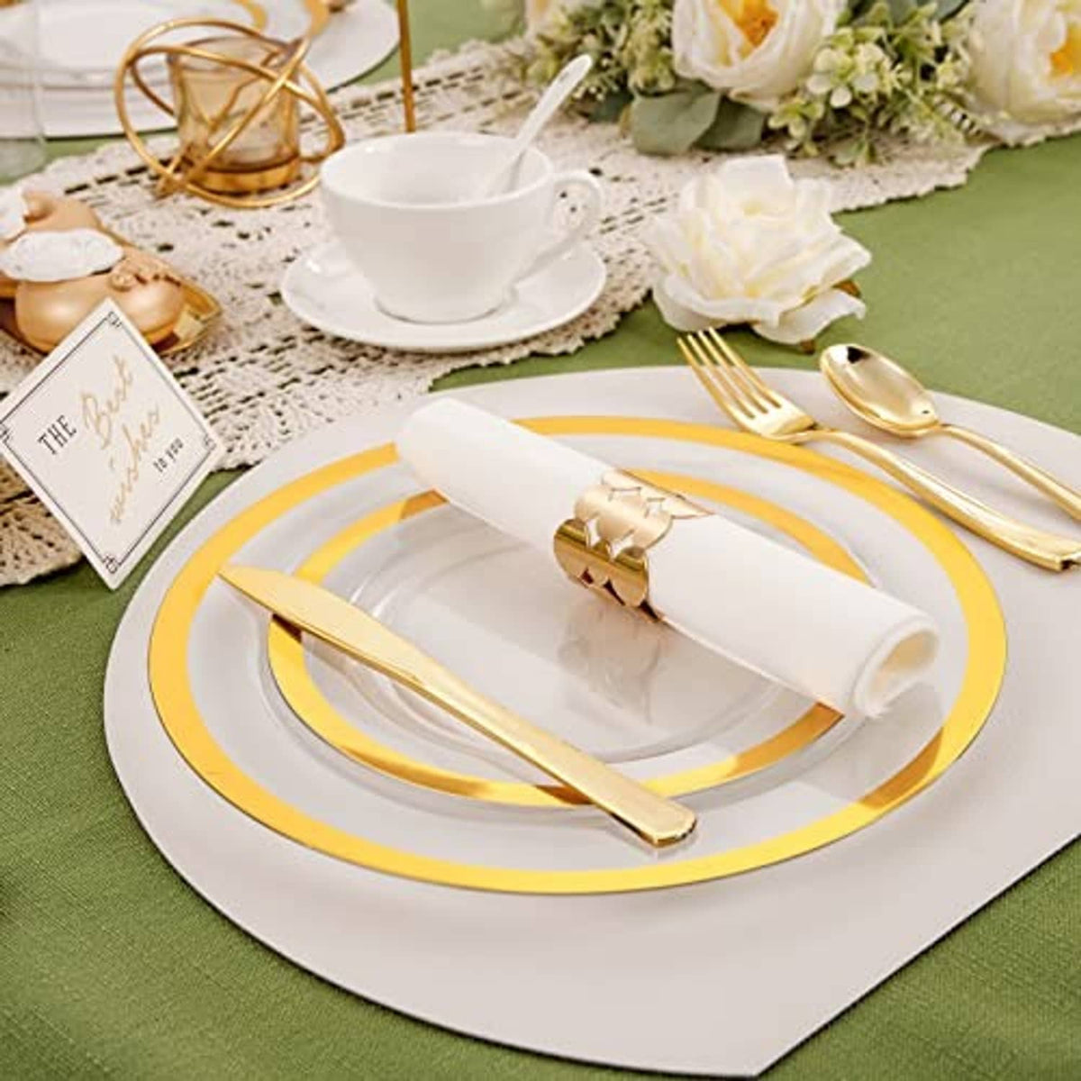 Gold-rim dinner plate with knife and fork, white napkin and clear cup