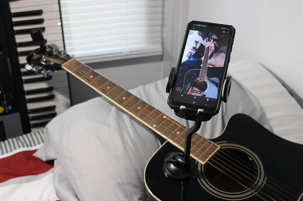 Guitar gooseneck phone holder with suction cup mounting phone on a guitar