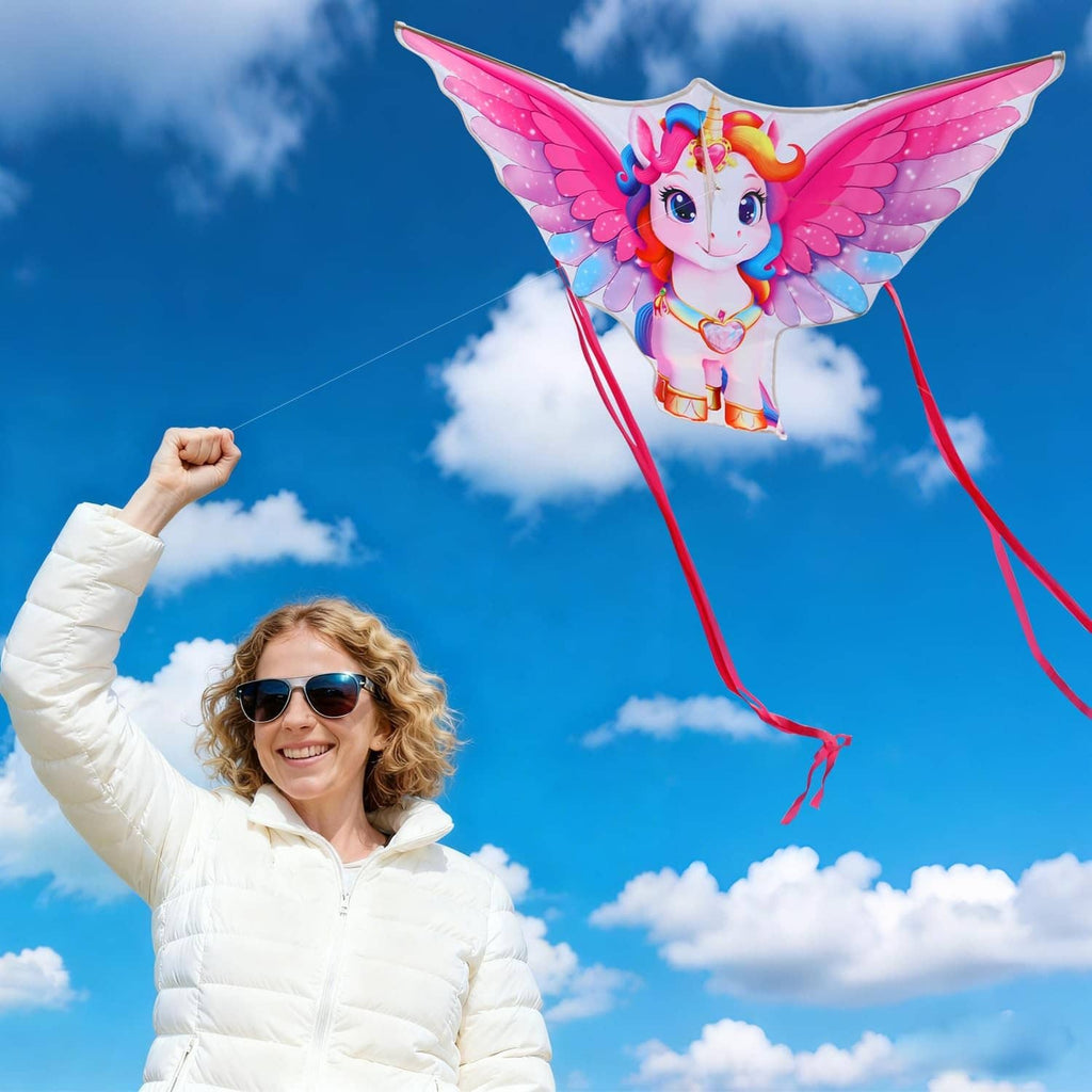 Unicorn kite flying with bright pink wings, rainbow mane, and four red ribbon tails