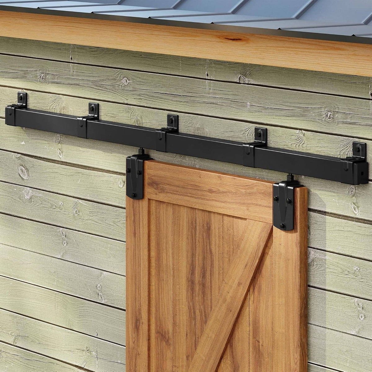 Black metal barn door rail with rollers holding a wooden door panel