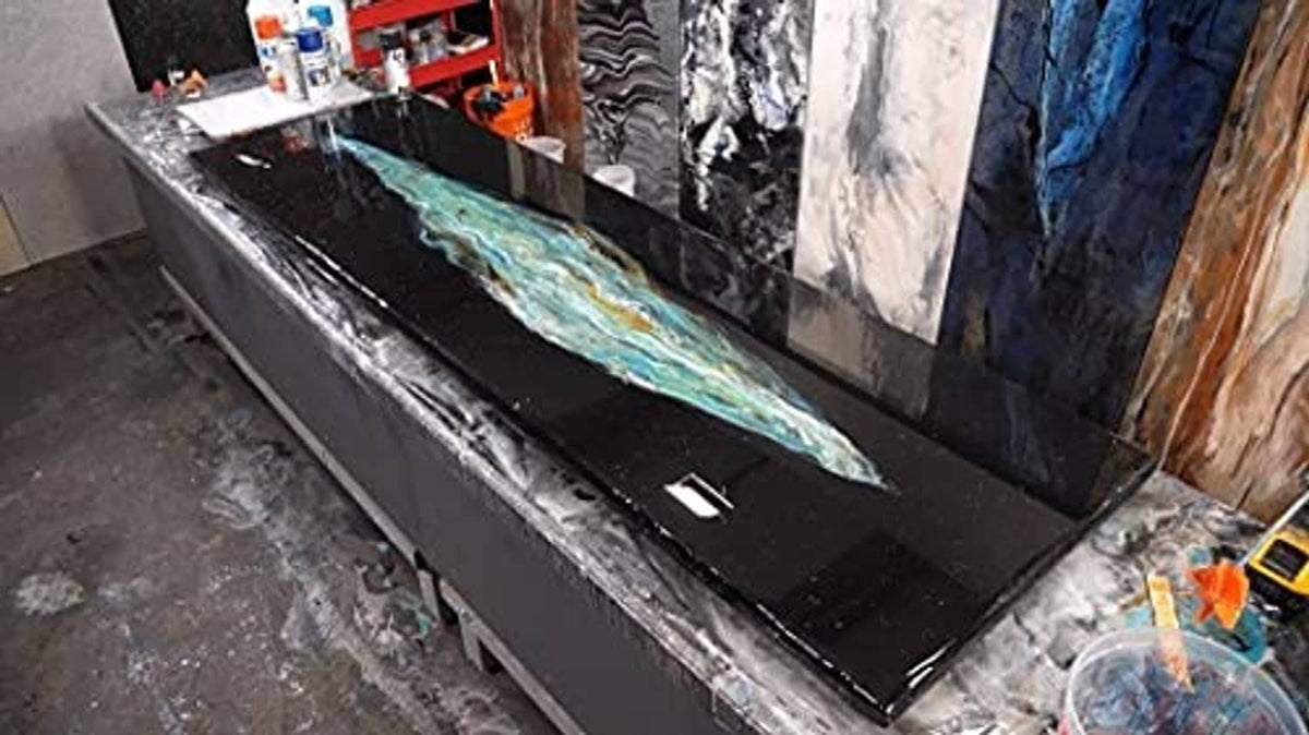 Black epoxy undercoat on a countertop, glossy surface with swirling streaks
