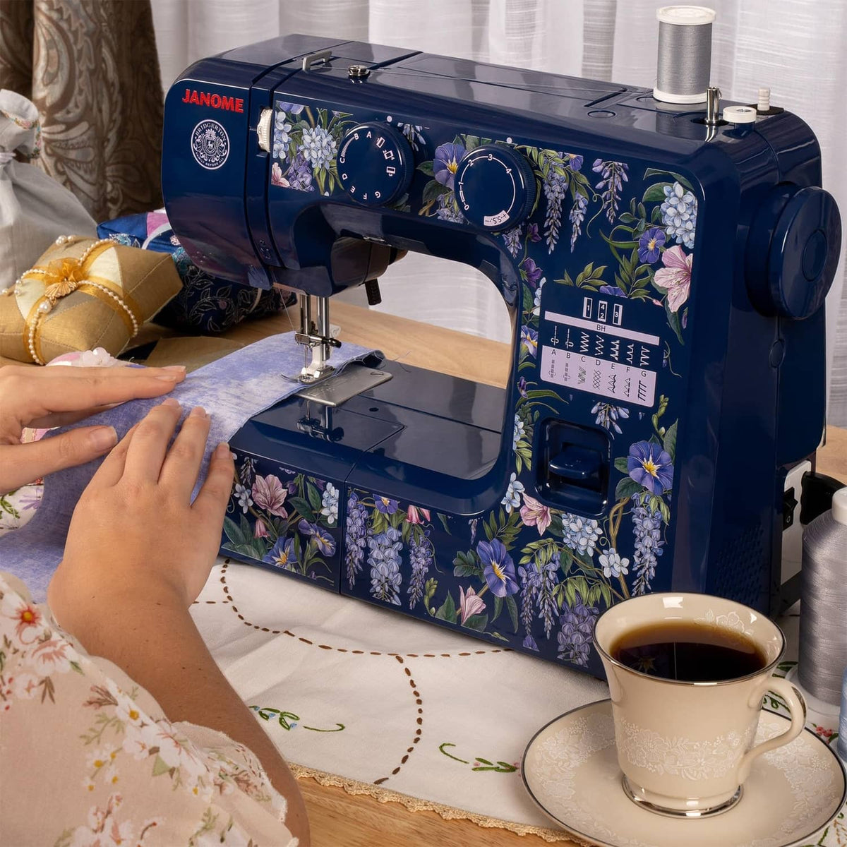 Indigo sewing machine with floral body, thread spool, and control panel