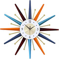 Starburst wall clock with white face, gold markers, multicolor rays, and black hands.