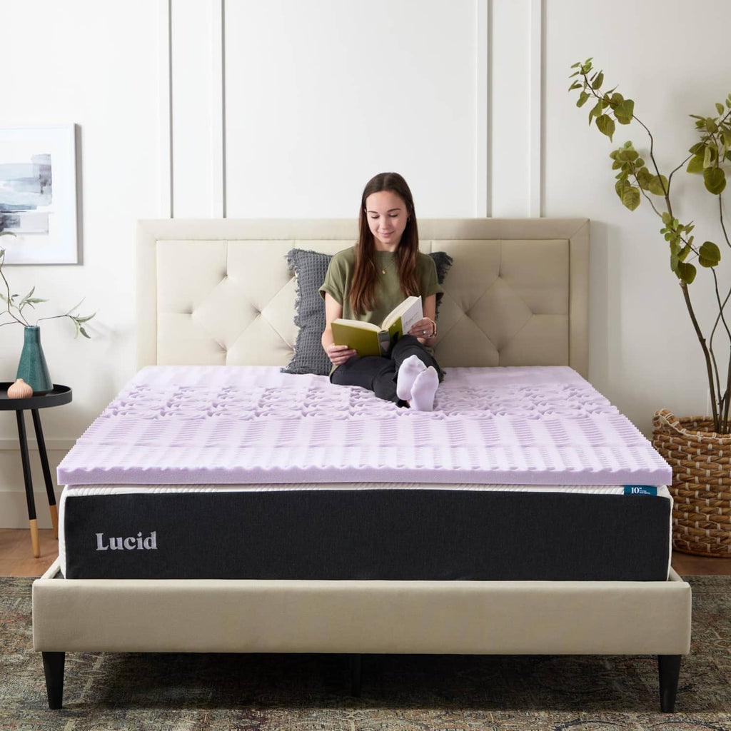 Lavender memory foam mattress topper on a bed with a person reading