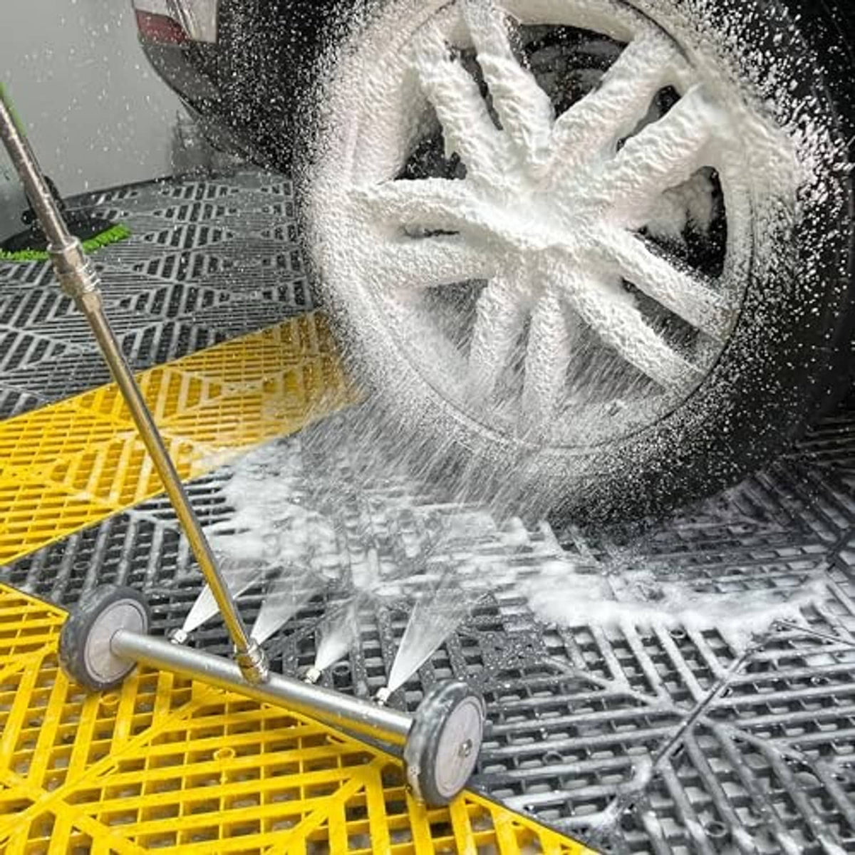 Vehicle wheel and tire covered in foam from undercarriage pressure washer attachment
