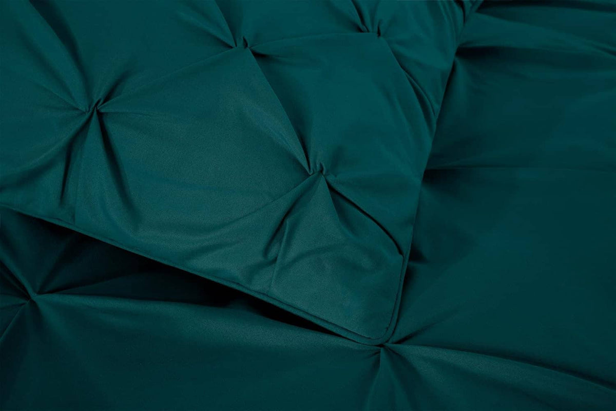 Teal comforter close-up with diamond tufted stitching and gathered seams