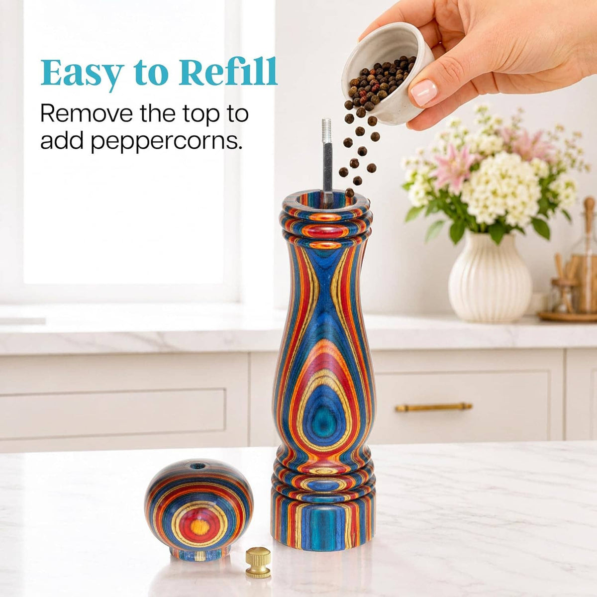 Colorful wooden pepper grinder with brass top, small cap removed for refilling