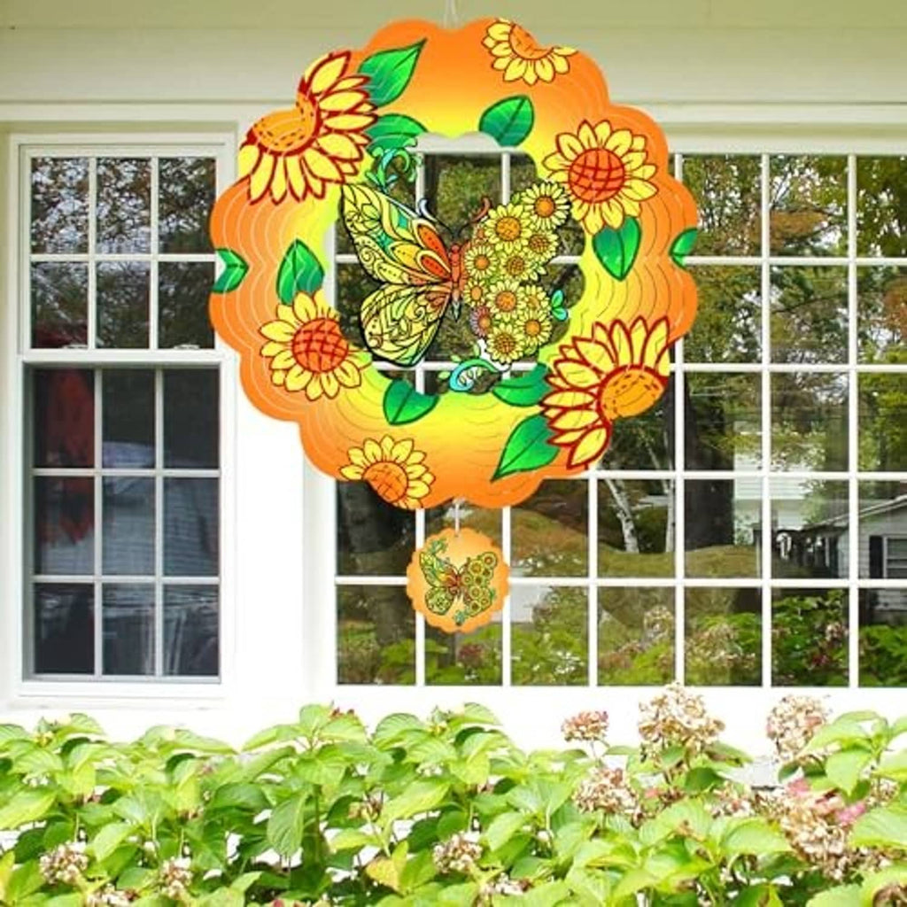 Butterfly wind spinner hanging in front of a window, orange floral petals with green leaves