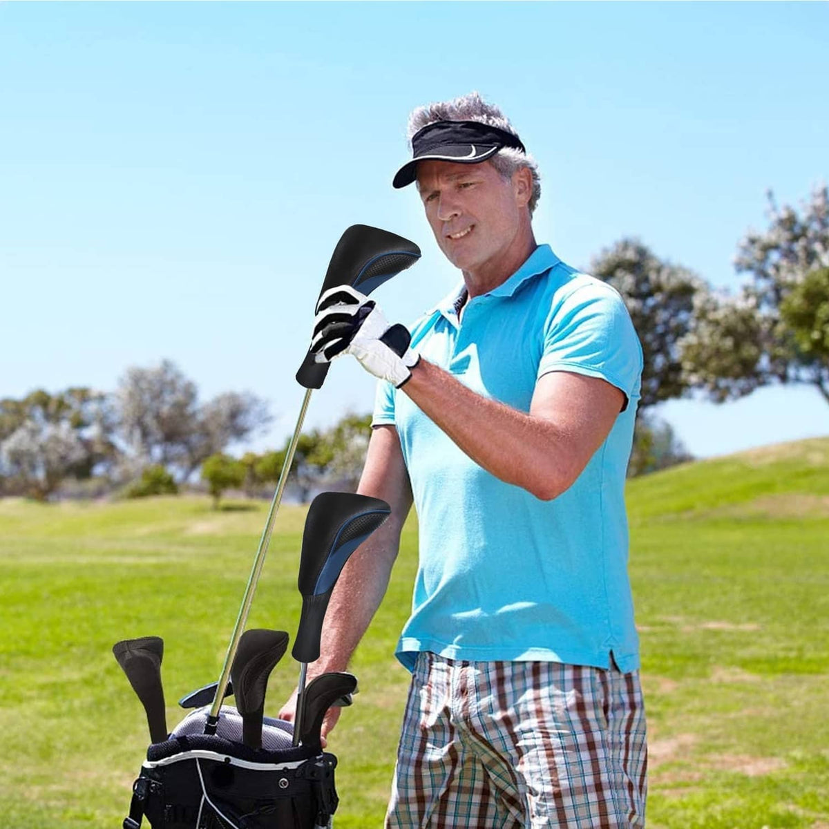 Golf club head covers on fairway woods, black with blue trim, on a golf bag