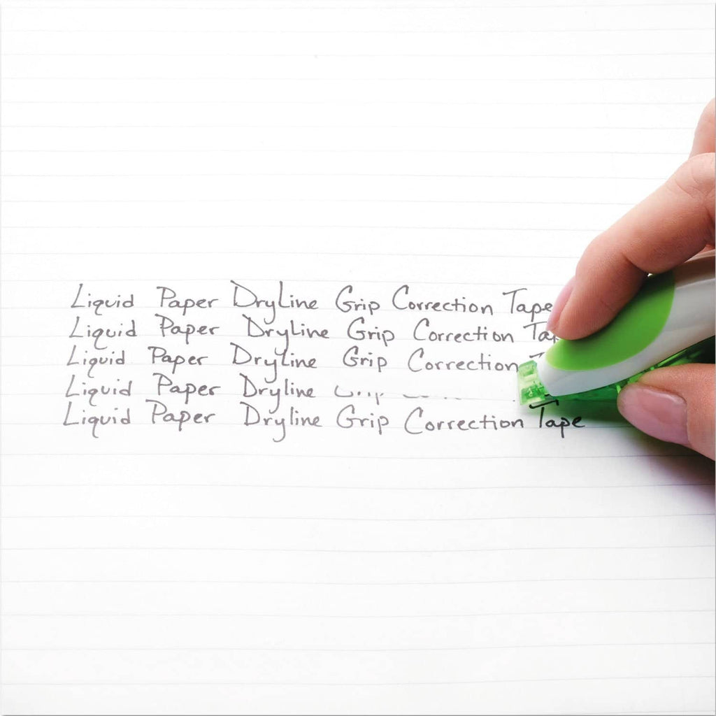 Hand using green correction tape on lined paper to cover printed text