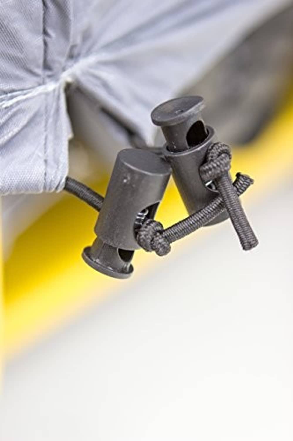 Gray generator cover cord with plastic fasteners at the front tie point