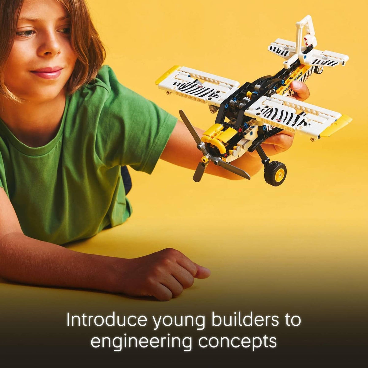 LEGO Technic bush plane toy held by a child, white body with black and yellow parts