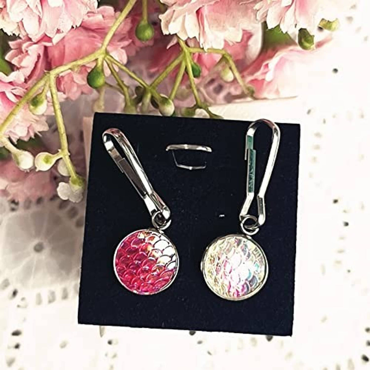 Pair of round iridescent scale zipper pull charms on black card backing
