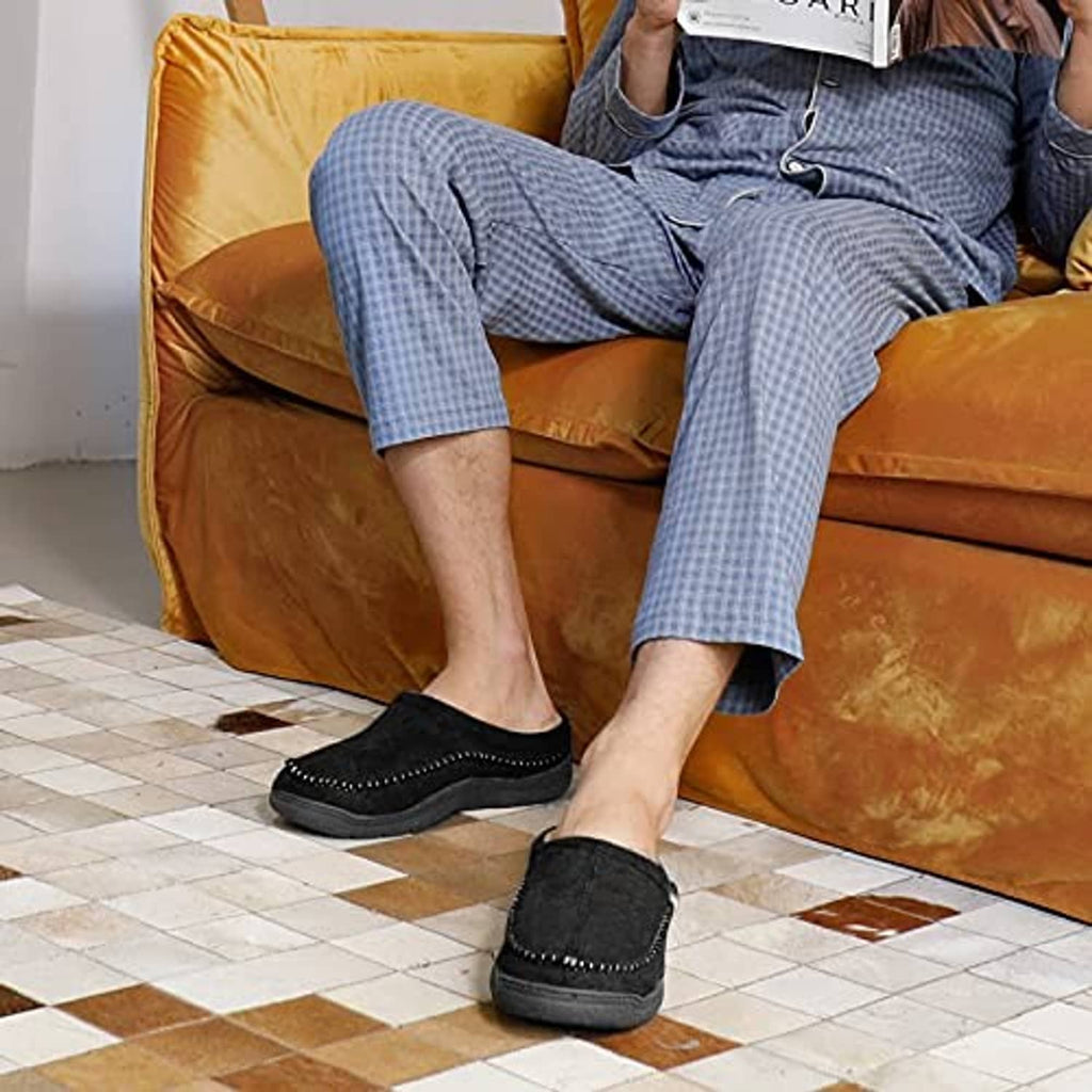 Men’s black moccasin slippers with fuzzy lining, worn with light-blue pants