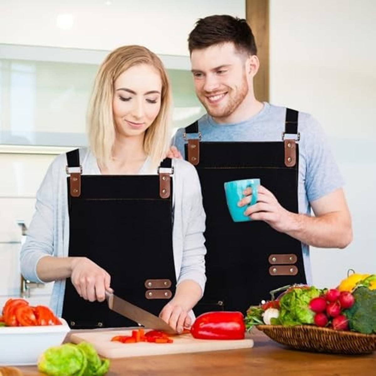 Black chef apron with adjustable brown leather straps and front utility pocket