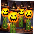 Glowing jack-o’-lantern pumpkin hanging light with black witch hat and green tentacles