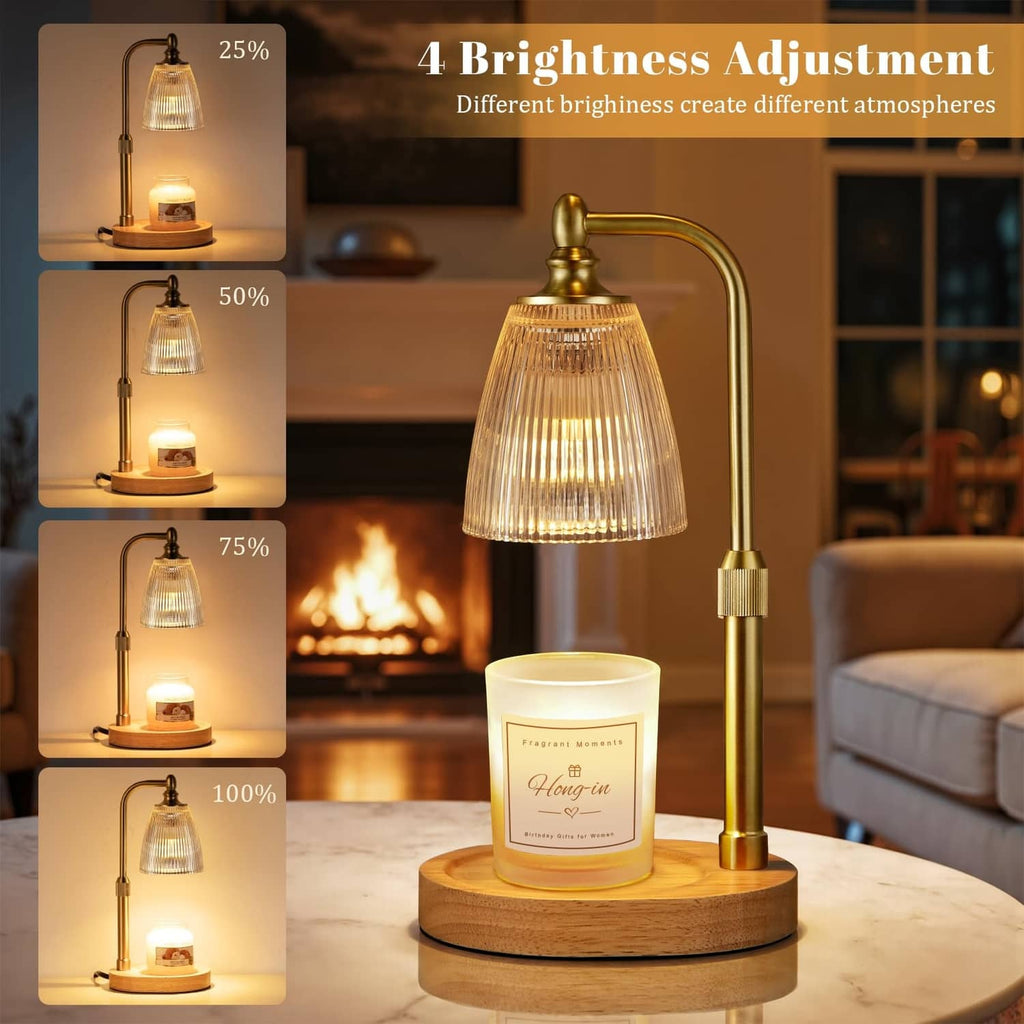 Brass candle warmer with clear bell glass shade over a lit jar candle