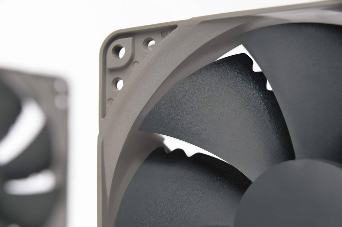 Close-up of 120mm cooling fan dark blade tips and gray frame corner