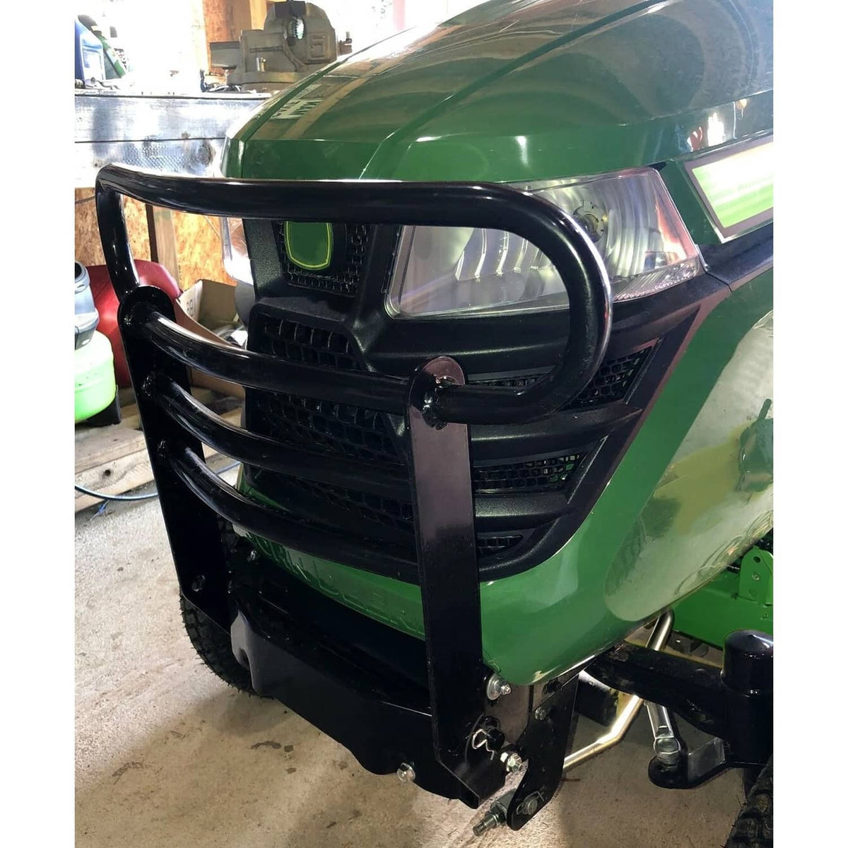 Black bumper brush guard installed on a riding mower front grille and headlights area