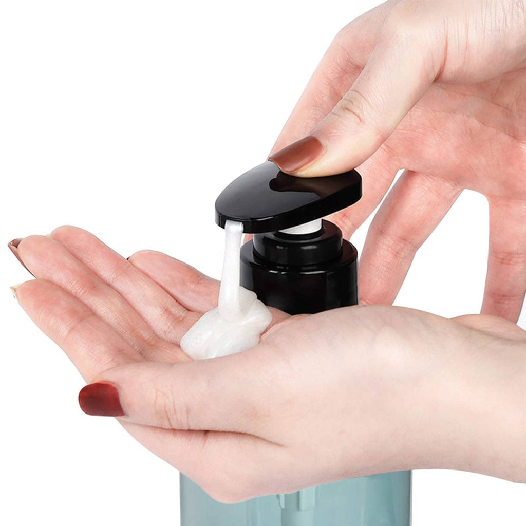 Hand pressing a black pump dispenser to release white foam from a teal bottle