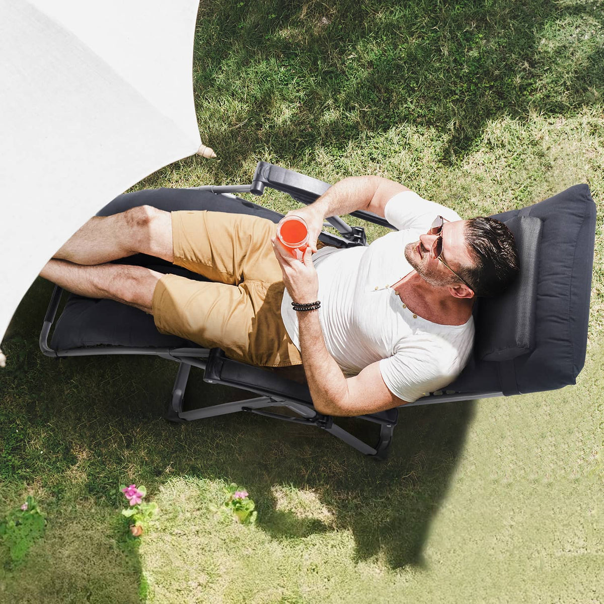 Black zero-gravity recliner chair in full recline with padded armrests and headrest