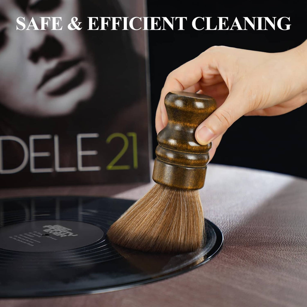 Brown soft brush with wooden handle lifting dust on a vinyl record