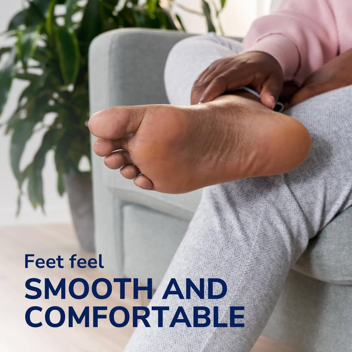 Electronic foot file near the foot on a seated person, dark blue with textured head