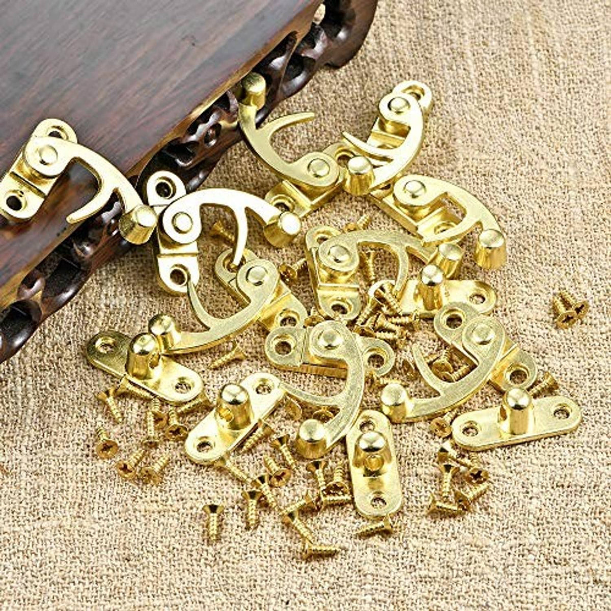 Antique gold jewelry box hardware pieces, curved latch and hinge parts in a pile