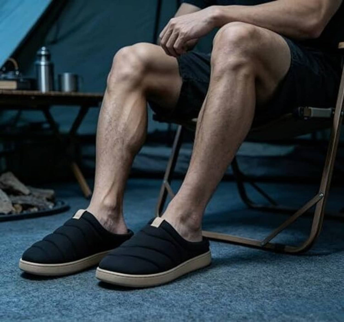 Black slide slippers with beige rubber sole, worn with shorts outdoors