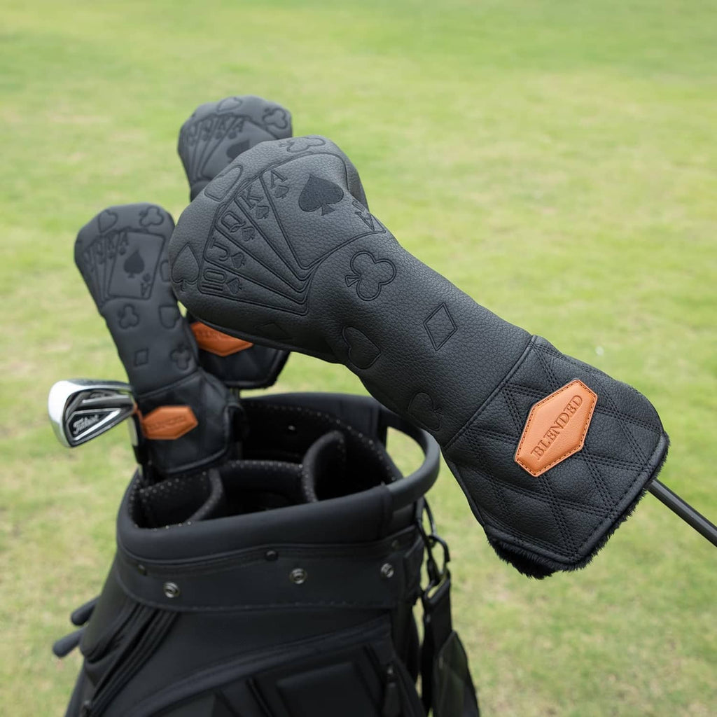 Black golf club head cover with textured poker pattern and tan logo patch, side view.