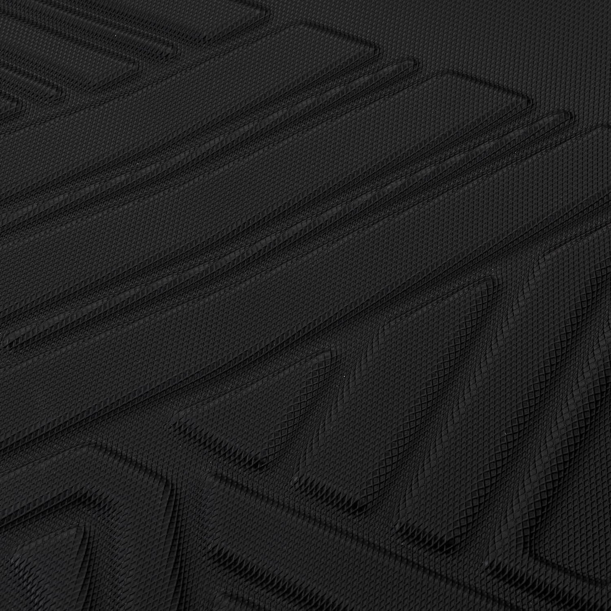 Close-up of black rubber floor mat texture with repeating diamond-pattern grip