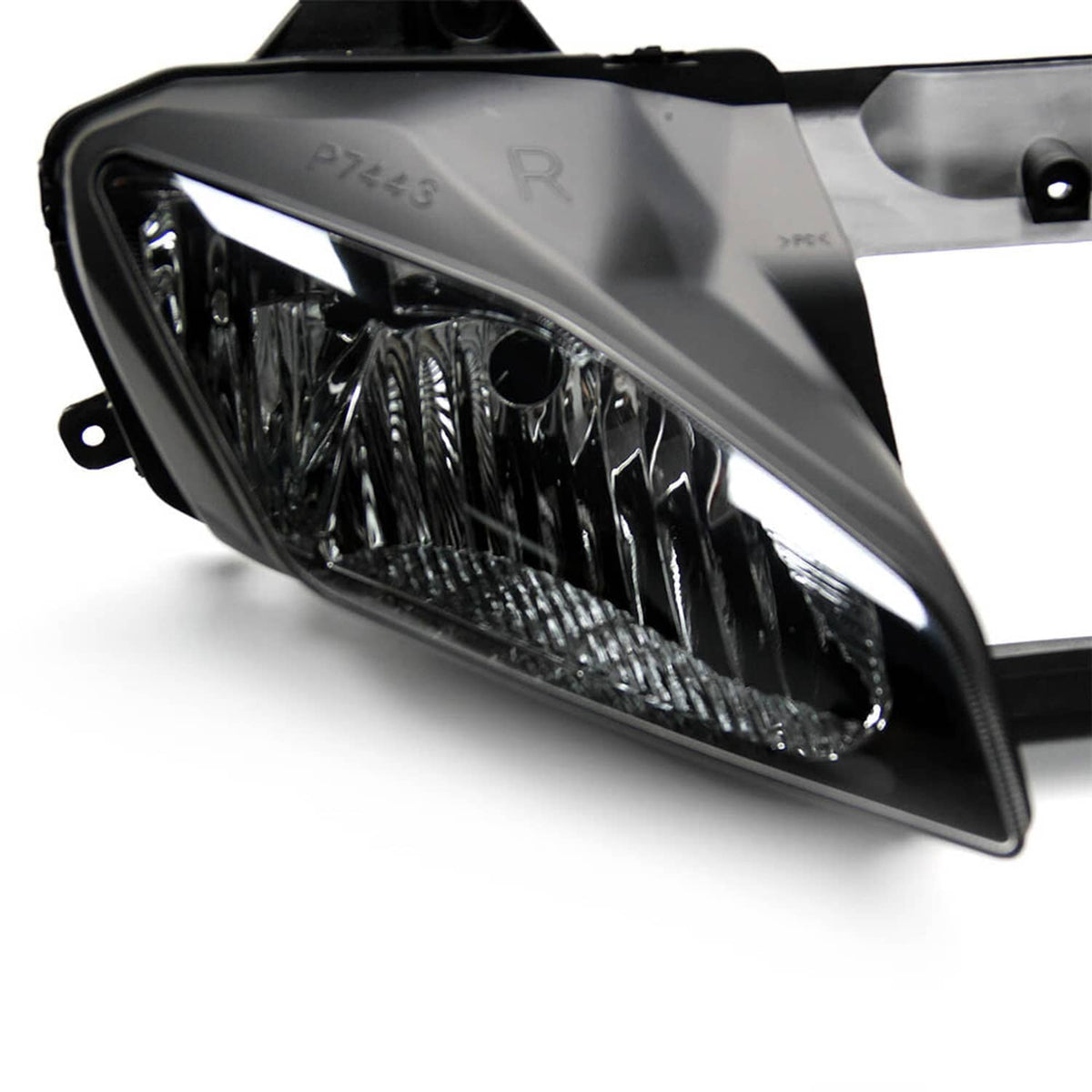 Close-up of left front headlight housing with clear lens and black mounting tabs