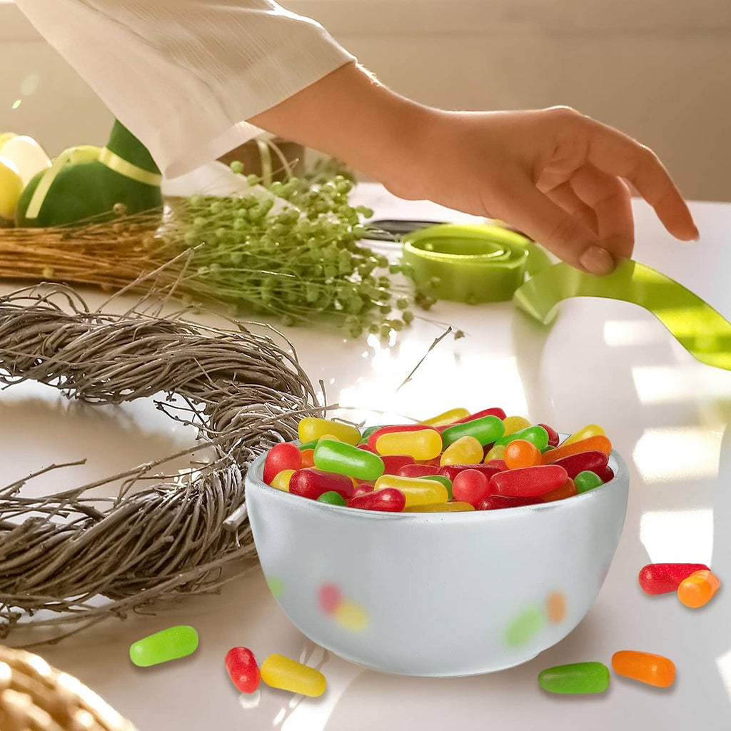 Assorted Mike and Ike candy in bowl with green dip cup and scattered candy pieces