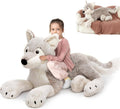 Large gray wolf plush stuffed animal with white muzzle and paws, lying down