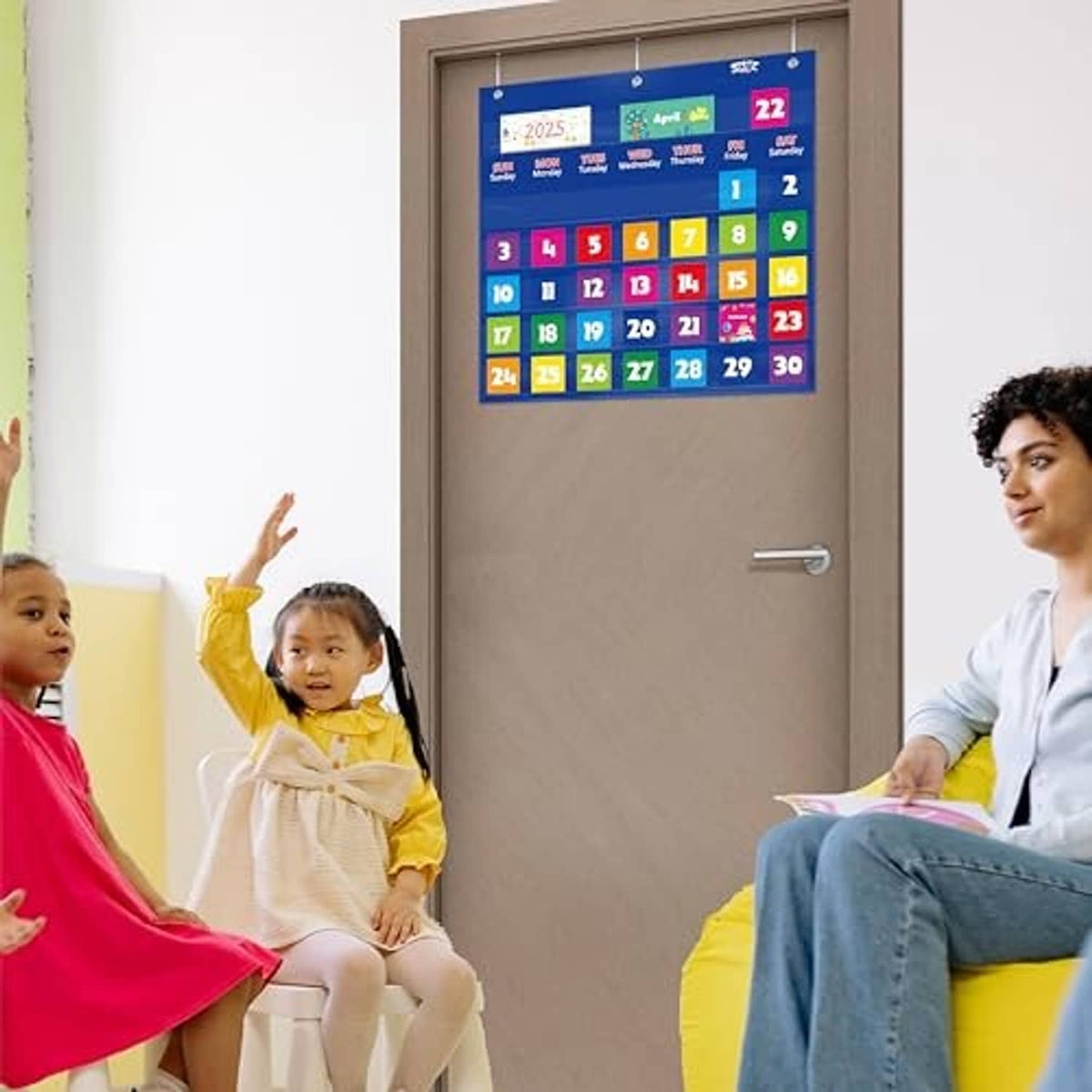 Blue classroom monthly pocket calendar chart mounted on wall with date numbers and month cards
