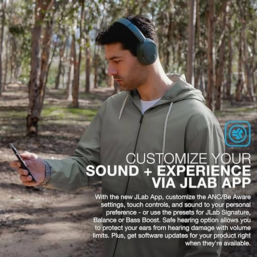 Sage green over-ear headphones worn by a man outdoors, looking down