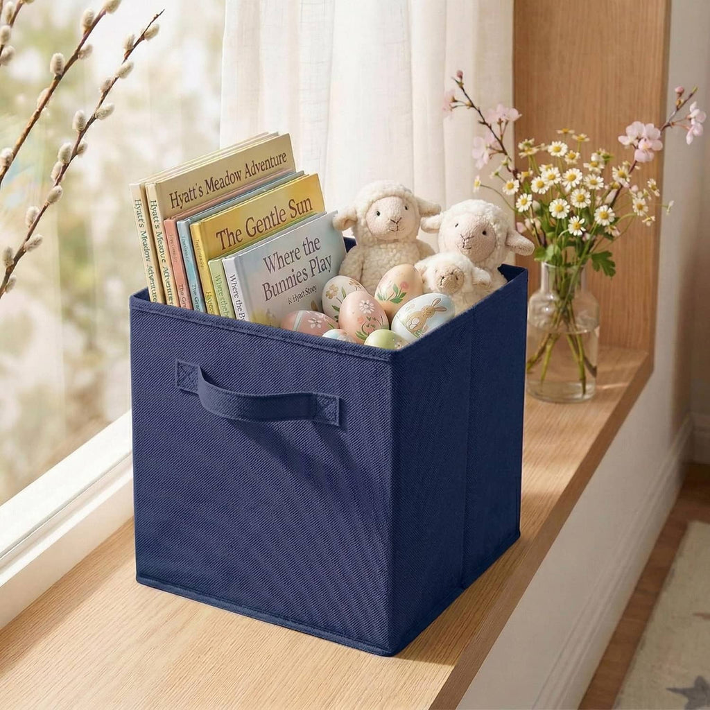 Dark blue fabric storage cube bin with open top and front handle on shelf